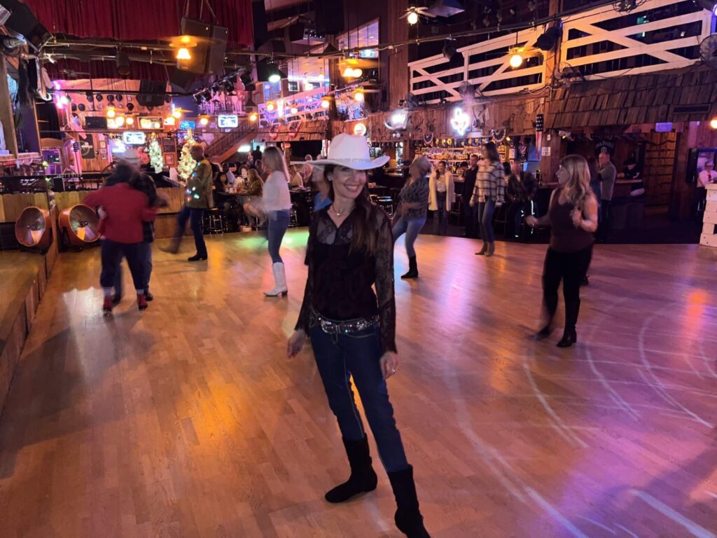 Linedancing teacher standing on dance floor.